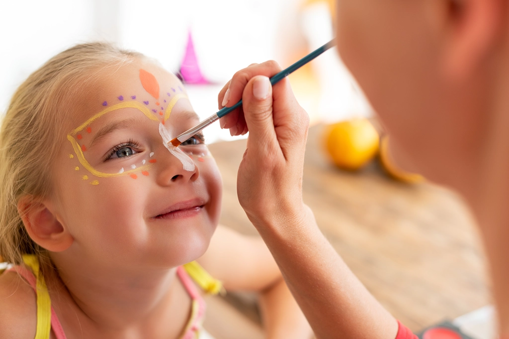 Little girl gets makeup done by an animator at the Chalets du Lac campground