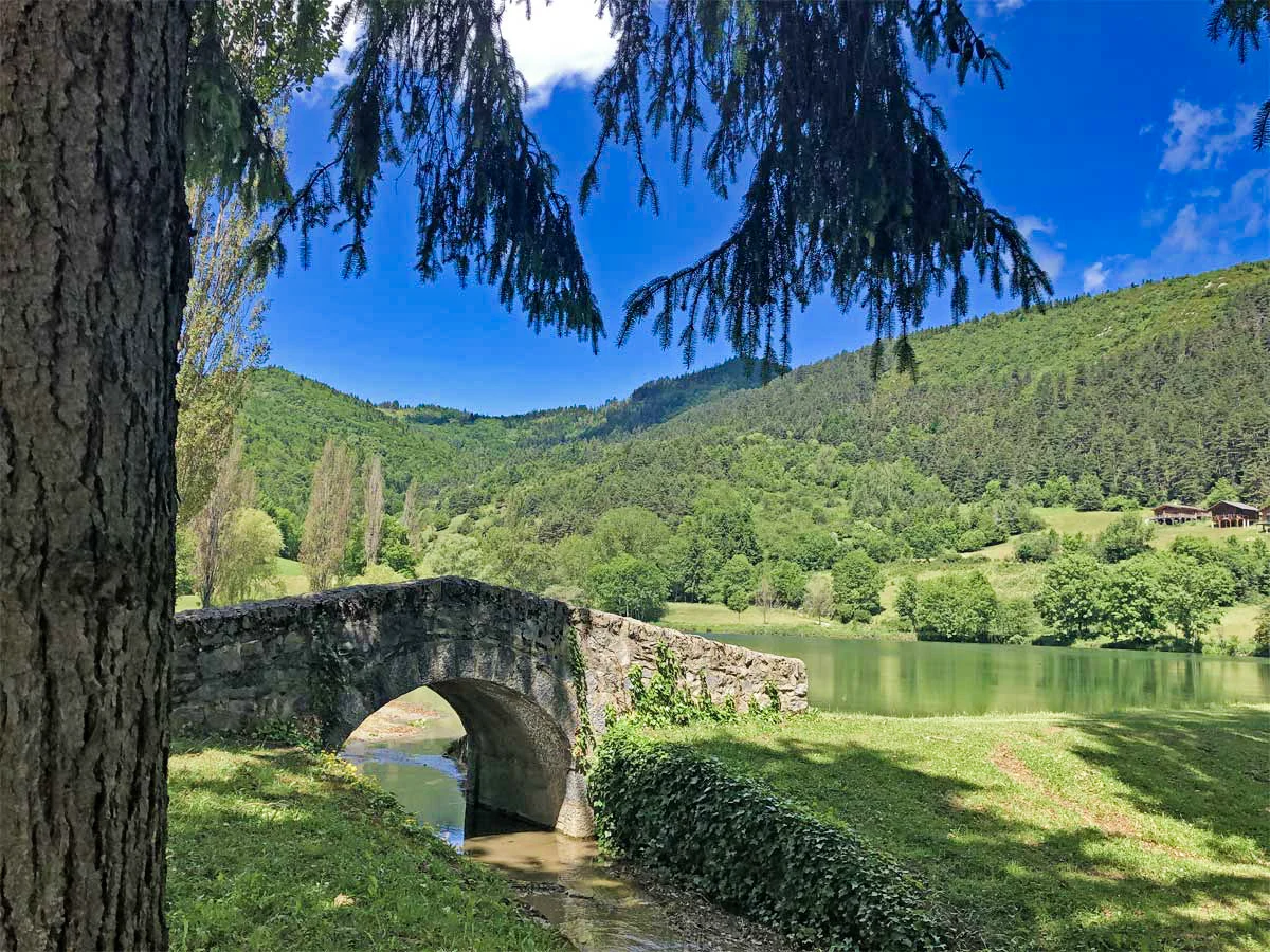 Pequeño puente de piedra alrededor del lago Belcaire en los Pirineos cátaros