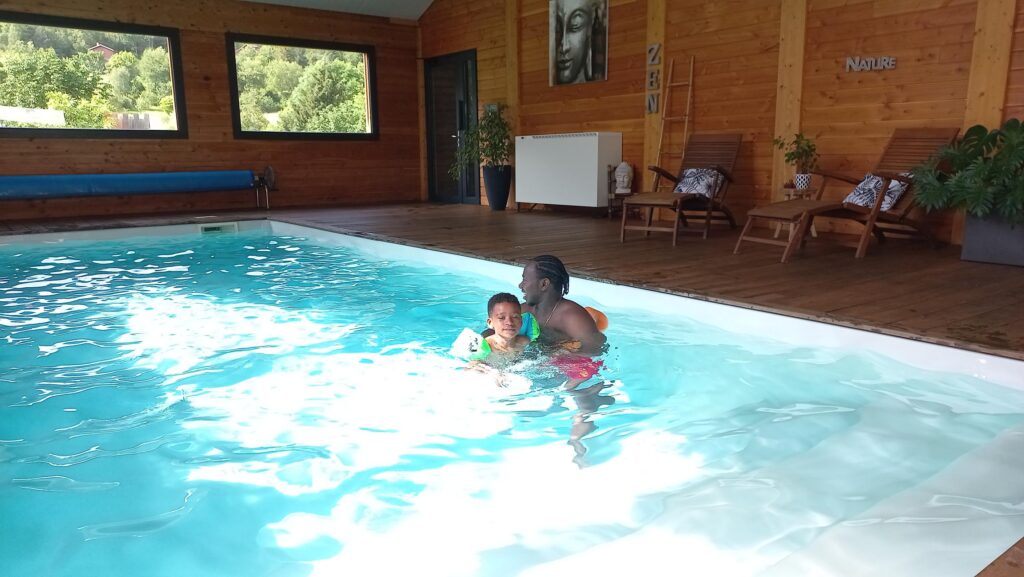 Dad and his child in the heated pool of the Chalets du Lac Belcaire