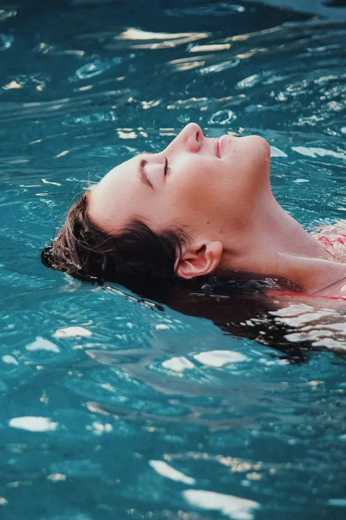femme se relaxe dans l'eau de la piscine des chalets du lac belcaire